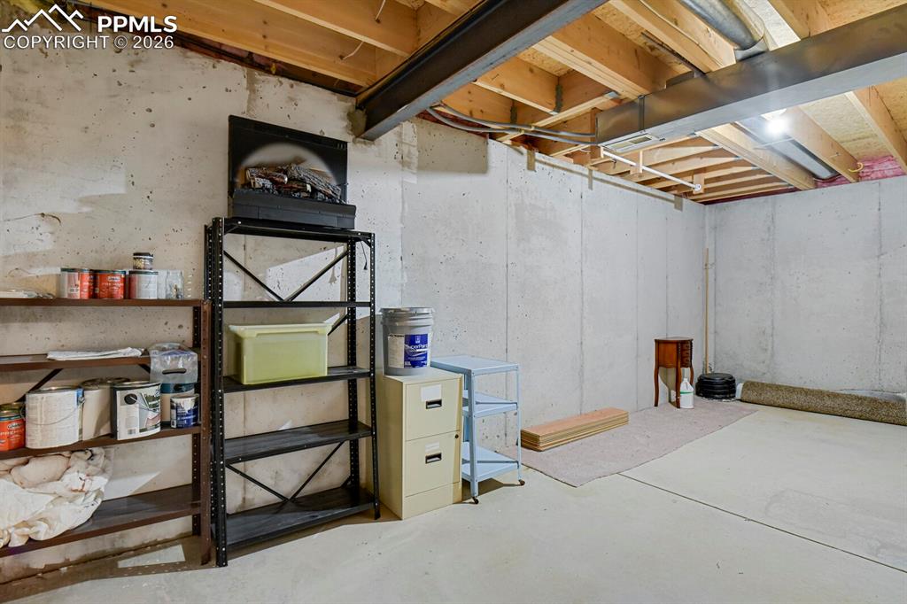 Image 41 of 50: The property features a utility room with concrete walls and a concrete flo