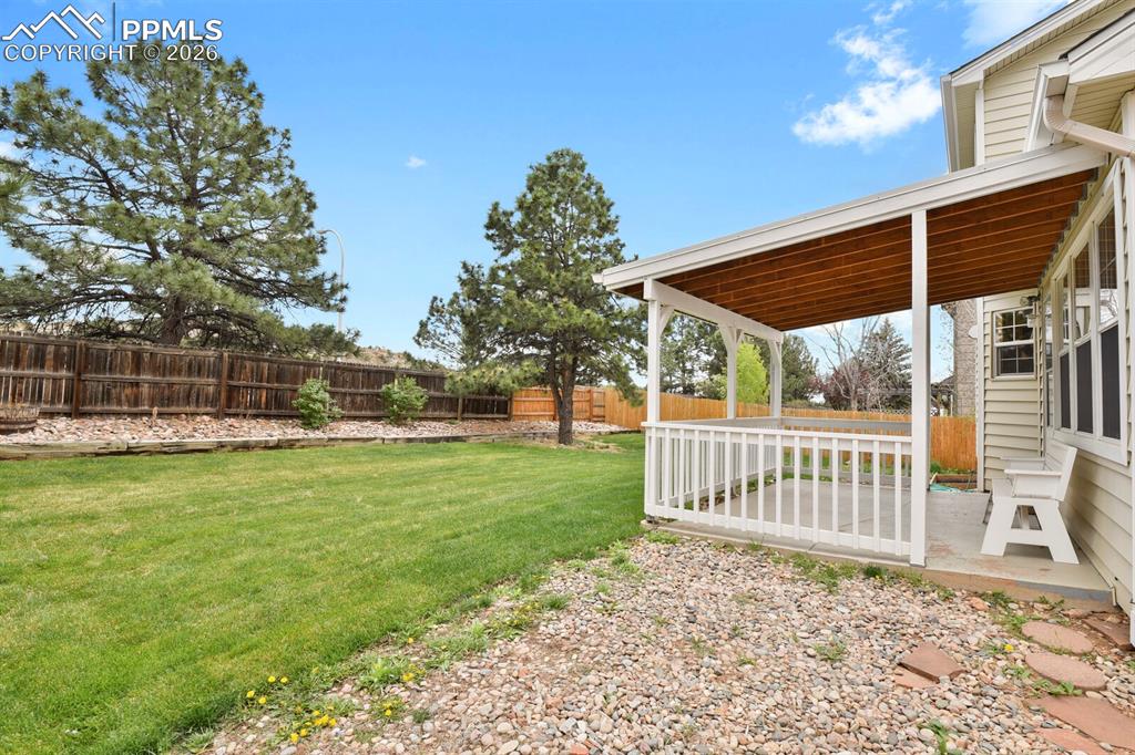 Image 46 of 50: The property includes a spacious backyard with a well-maintained lawn, matu