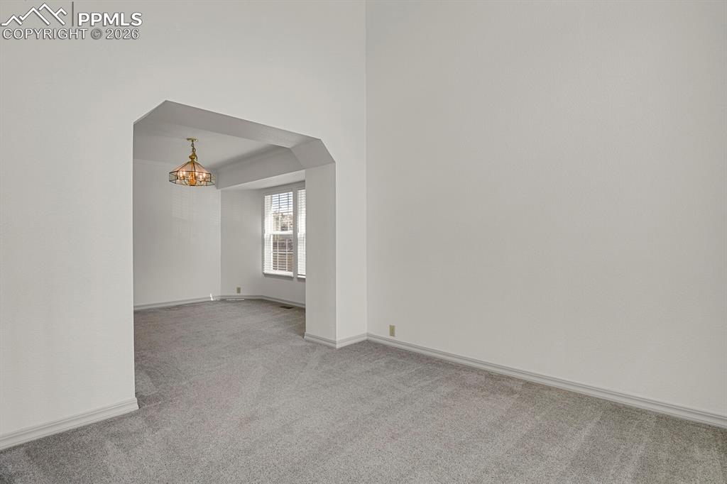 Image 5 of 50: This interior space features light grey carpeting and light-colored walls t