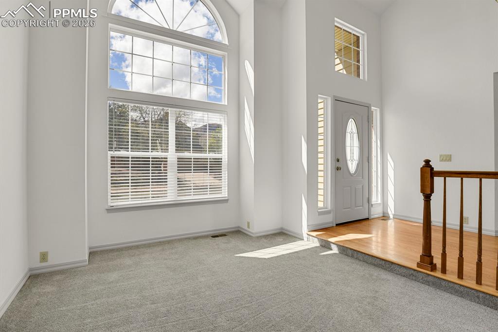 Image 7 of 50: Inviting entry area featuring a large arched window, a front door with an o