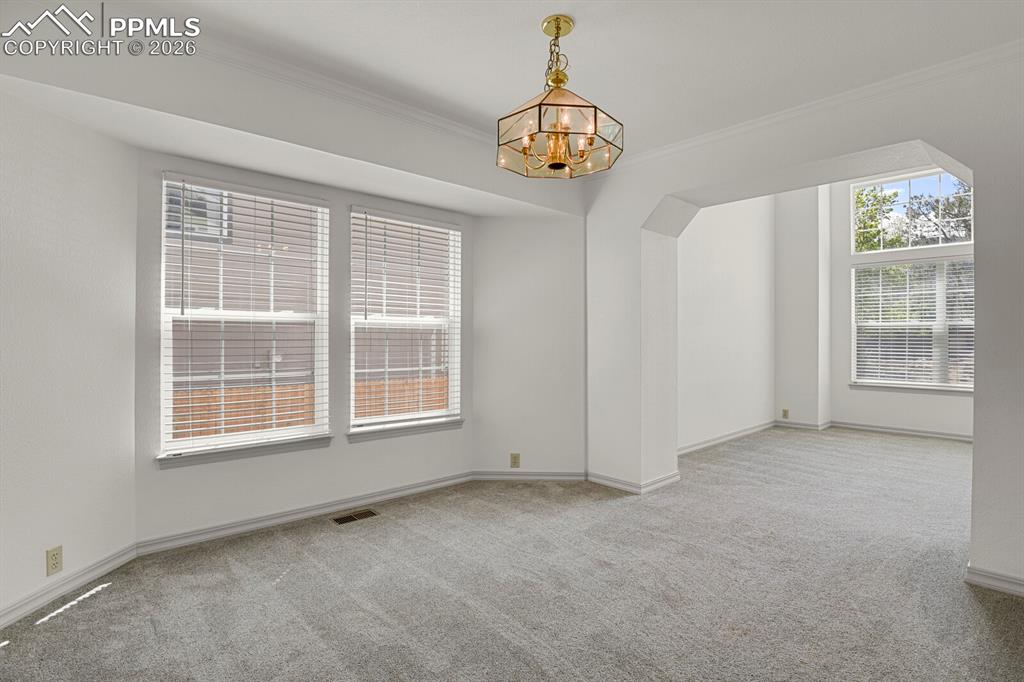 Image 8 of 50: Bright room featuring light grey carpet, white walls, and multiple windows 