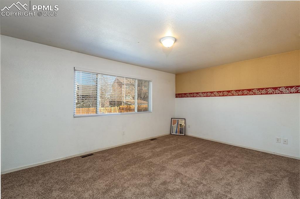 Image 13 of 31: Spare room featuring visible vents and carpet floors