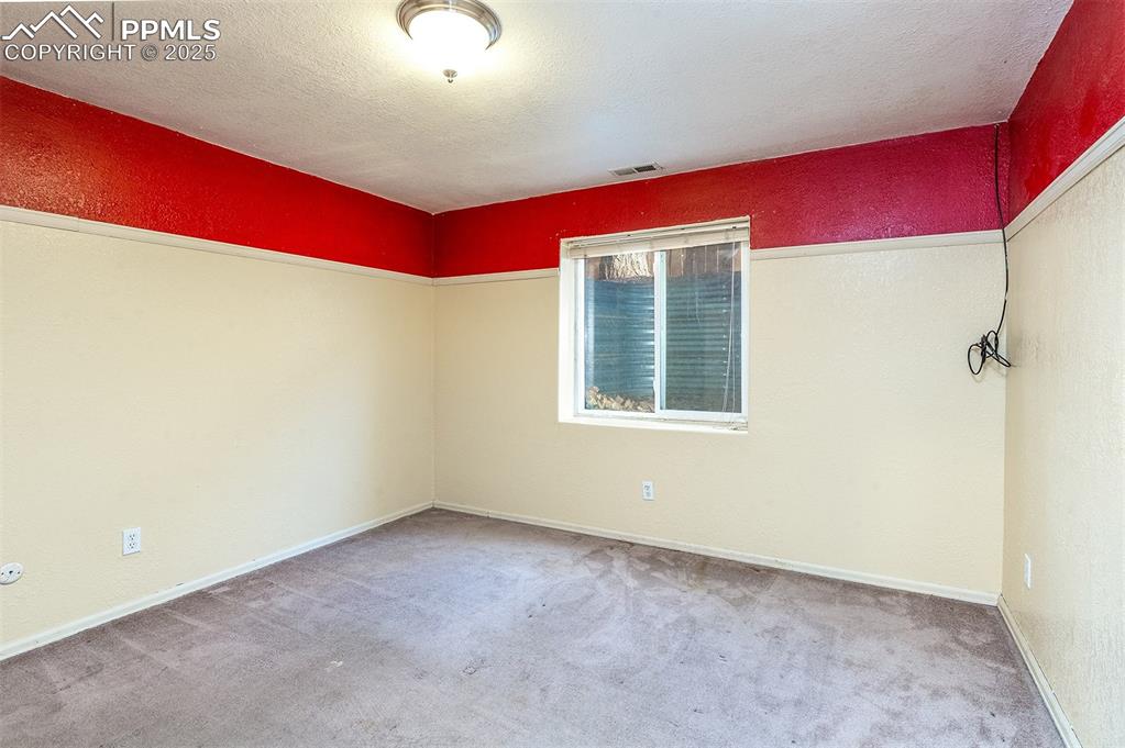 Image 20 of 31: Empty room with baseboards, visible vents, carpet floors, a textured ceilin