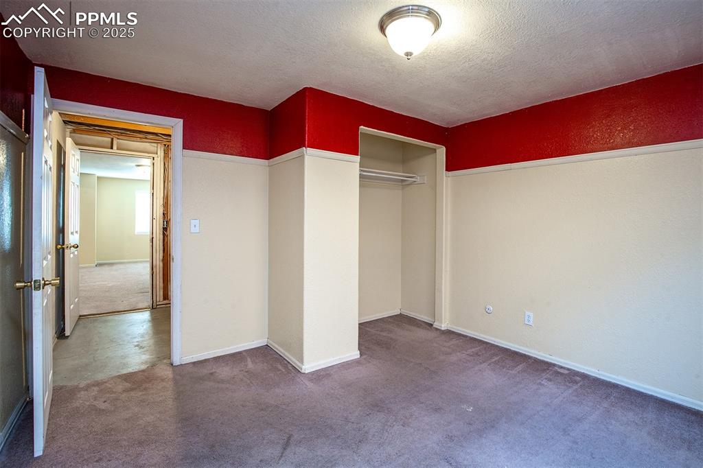 Image 21 of 31: Unfurnished bedroom with a closet, a textured ceiling, carpet, and a textur