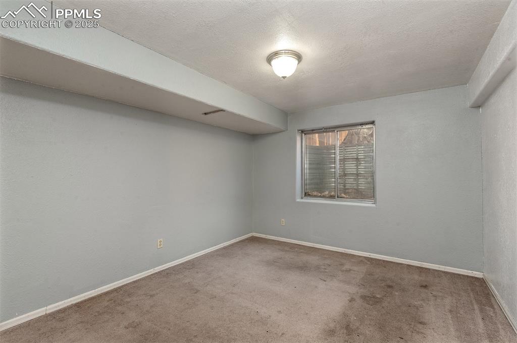 Image 22 of 31: Carpeted spare room featuring visible vents, baseboards, and a textured cei