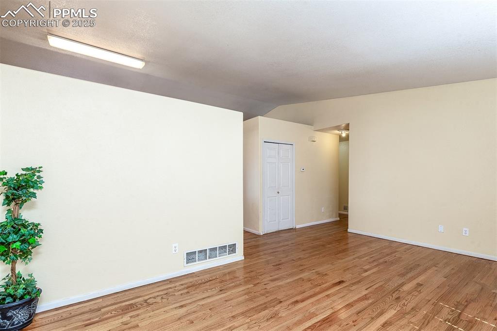 Image 3 of 31: Spare room featuring lofted ceiling, baseboards, visible vents, and light w