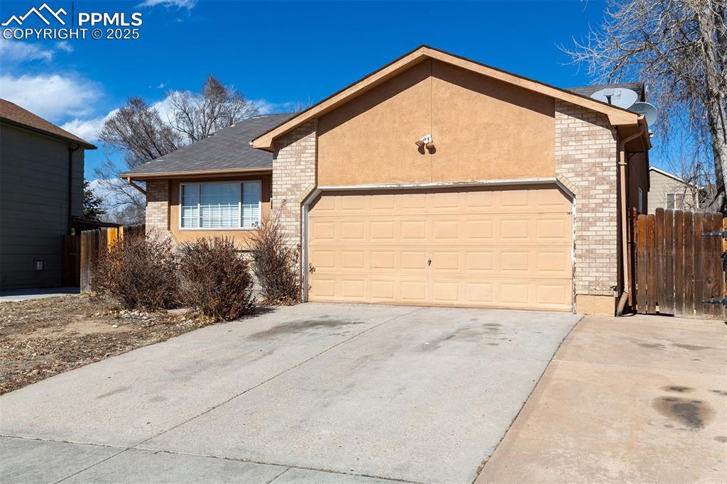 Image 31 of 31: Ranch-style house featuring concrete driveway, brick siding, and a garage