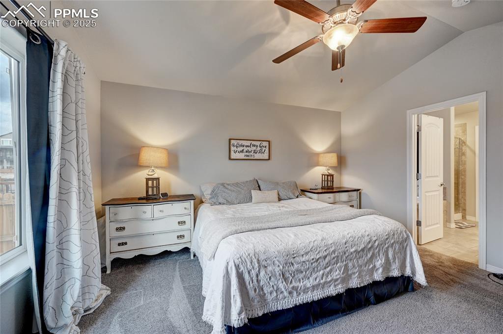 Image 19 of 50: Primary bedroom with vaulted ceilings
