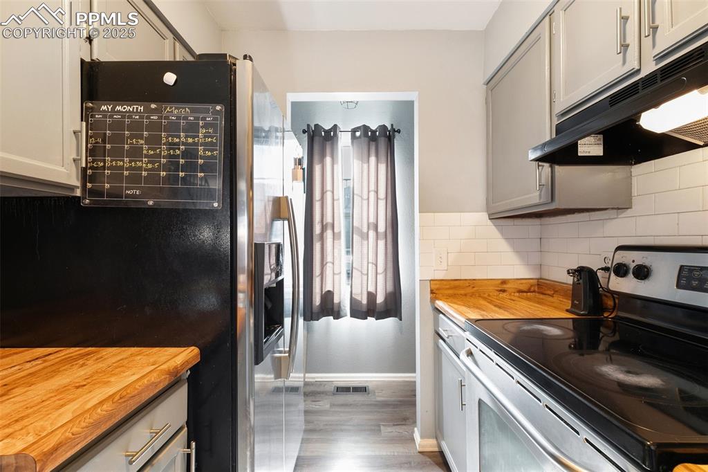 Image 14 of 28: Kitchen featuring appliances with stainless steel finishes, wooden counters