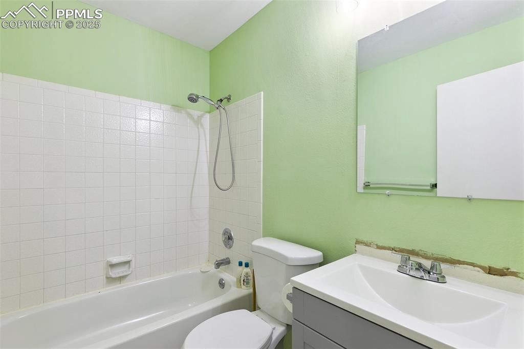 Image 22 of 28: Bathroom featuring vanity,  shower combination, and a textured wall