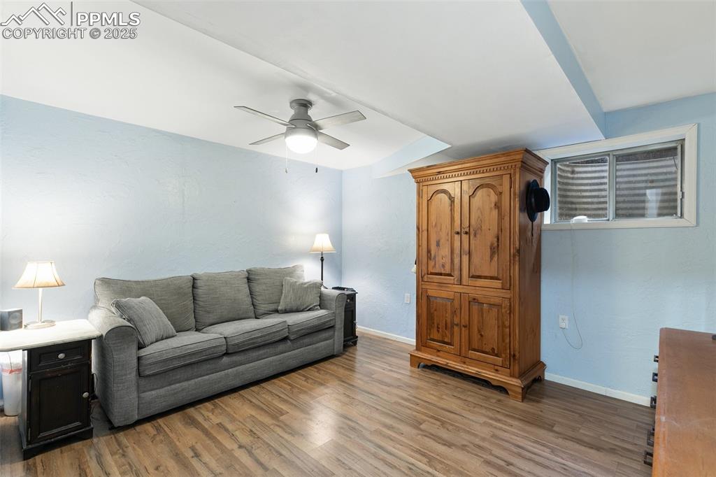 Image 24 of 28: Living area with light wood-style flooring and ceiling fan