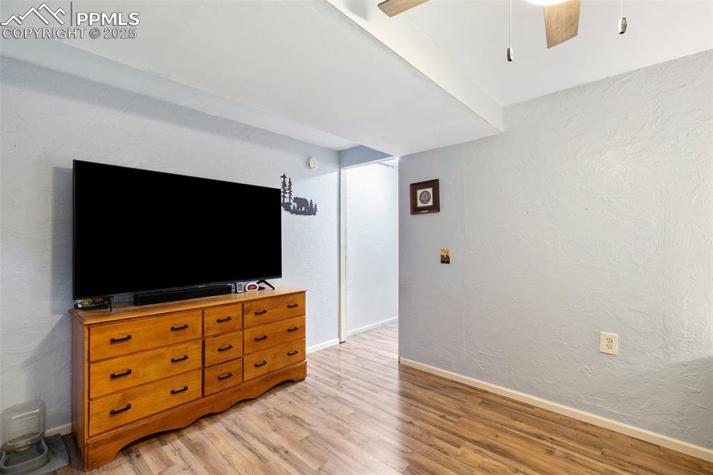 Image 25 of 28: Living room featuring light wood-type flooring, a ceiling fan, and a textur