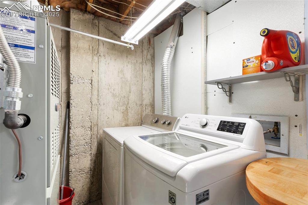 Image 27 of 28: Laundry area featuring separate washer and dryer and heating unit