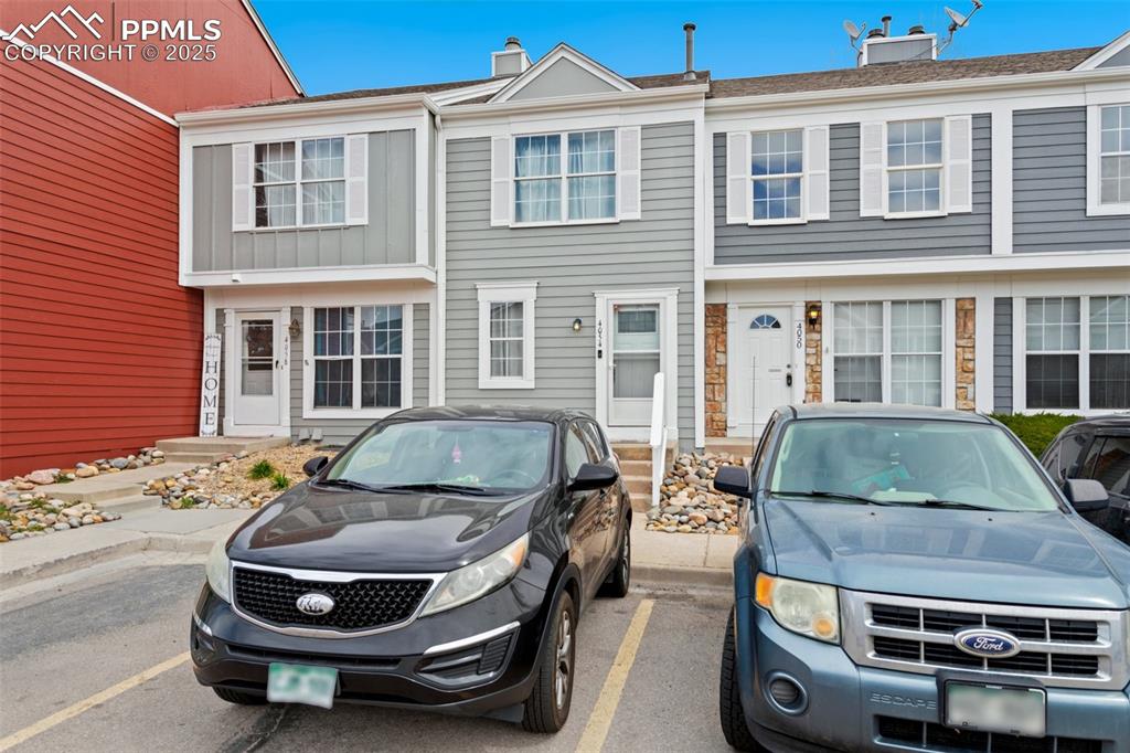 Image 3 of 28: View of front facade with a chimney, uncovered parking, and board and batte