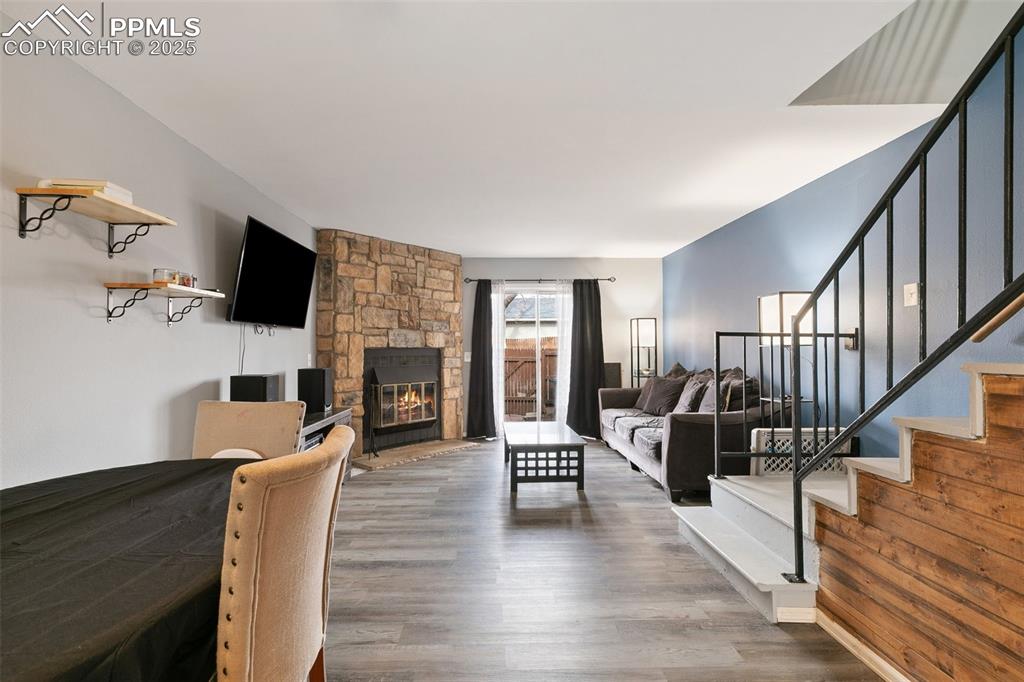 Image 5 of 28: Living area featuring wood finished floors, stairs, and a fireplace