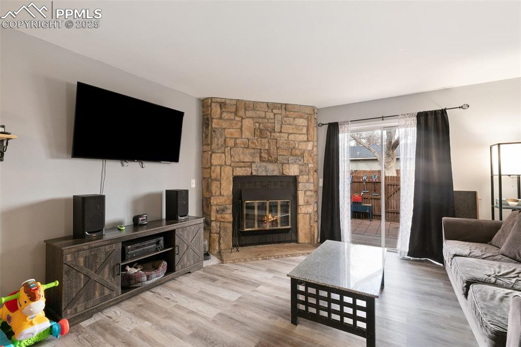 Image 7 of 28: Living room featuring wood finished floors and a fireplace