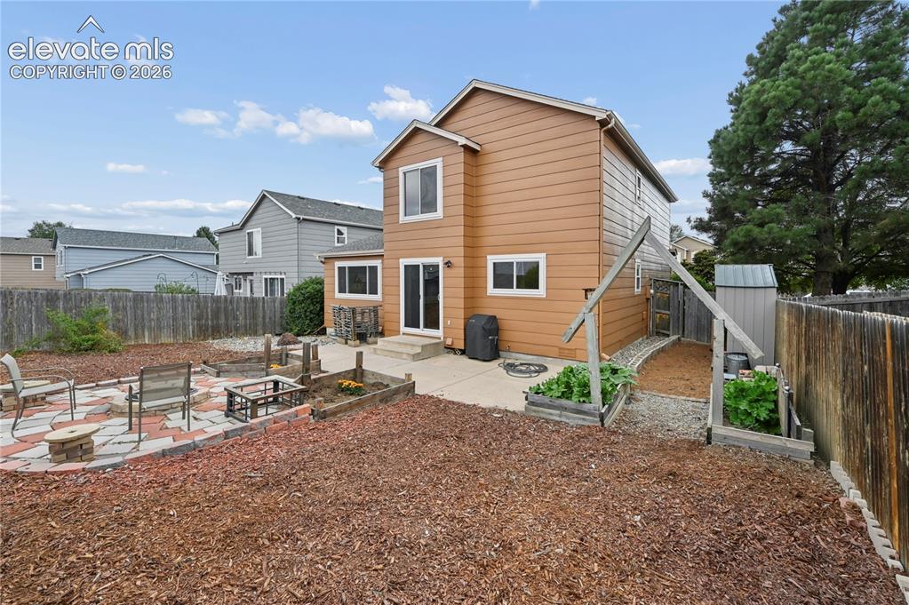 Image 13 of 41: Patios, arbor, garden areas, and nearby storage shed