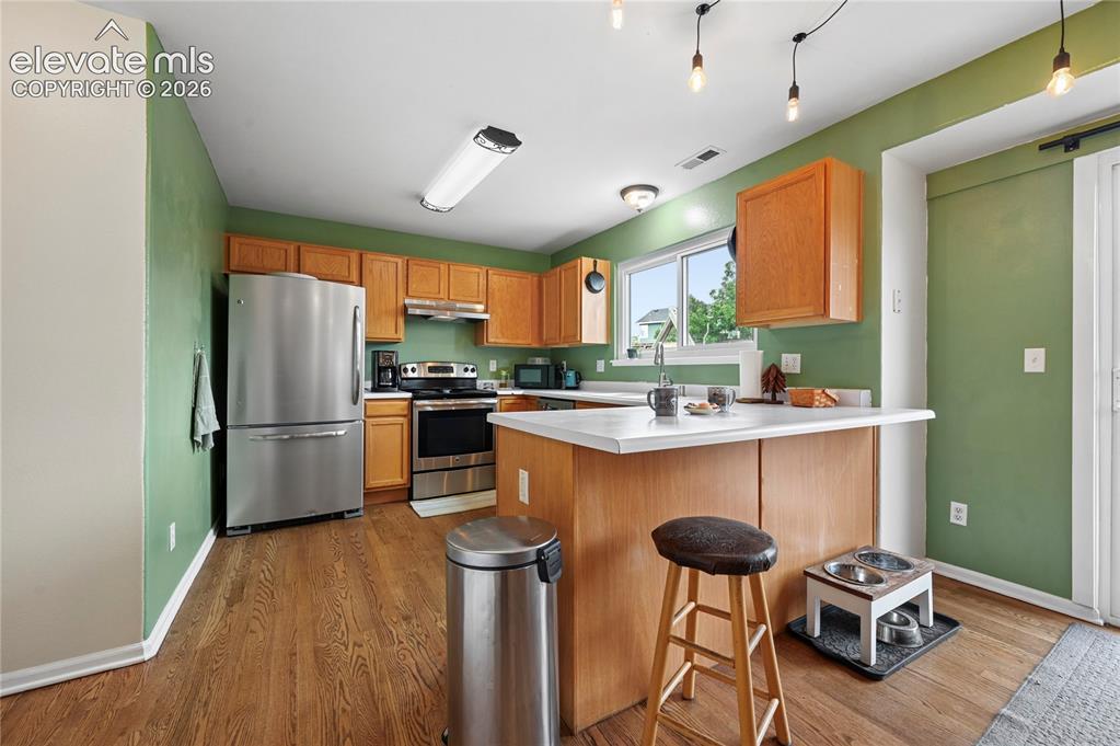 Image 14 of 41: Breakfast bar or serving counter between the dining room and kitchen