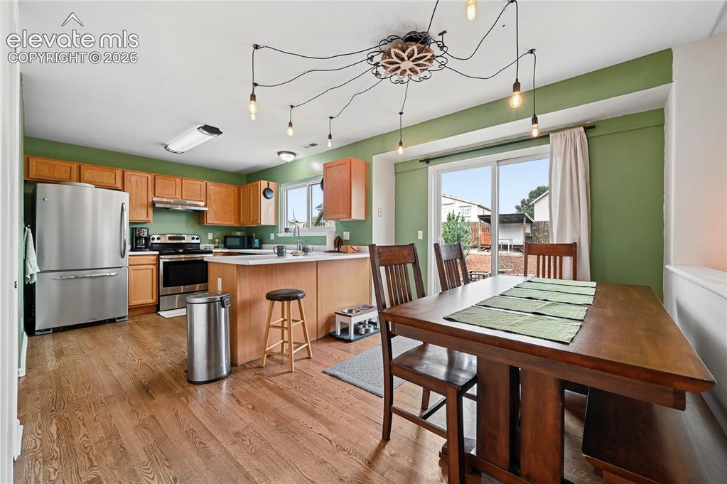 Image 9 of 41: Dining room with custom lighting and easy flow to the kitchen as well as ou