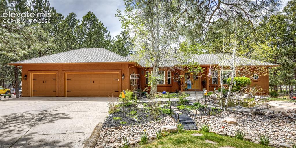 Image 1 of 50: Stucco exterior residence with a concrete driveway leading to a two-car gar