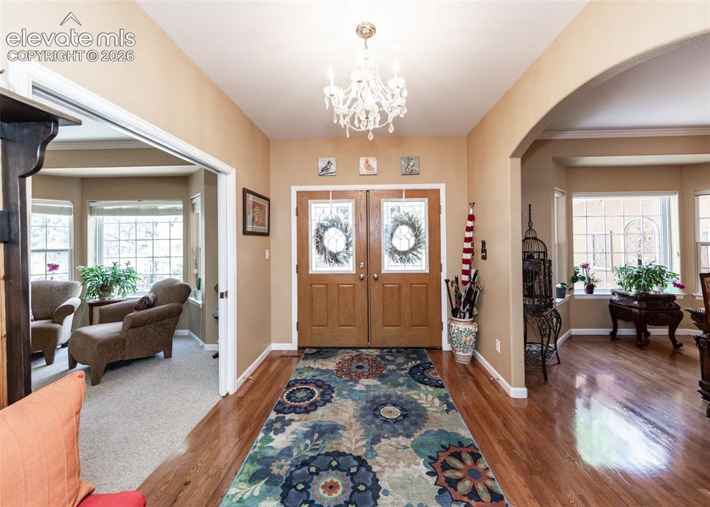 Image 11 of 50: Entryway featuring wood-finish flooring, a decorative chandelier, and a dou