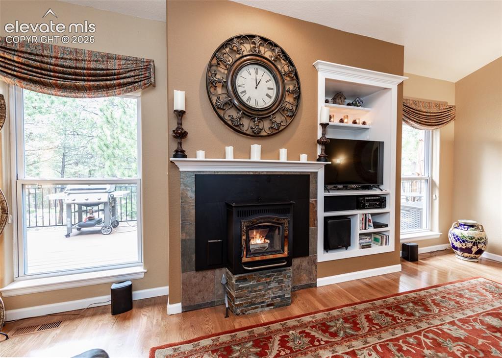 Image 20 of 50: Living space featuring wood-finish flooring and a stone-clad fireplace with