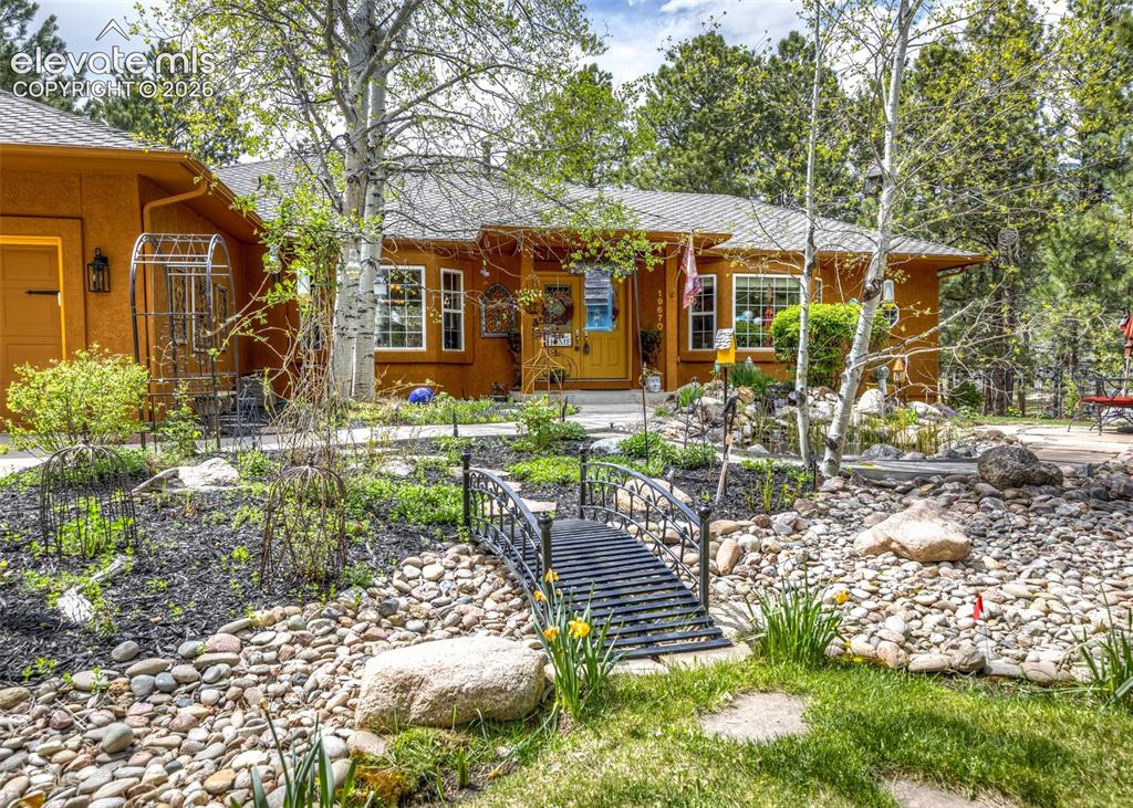 Image 3 of 50: Ranch-style residence featuring an orange stucco exterior, white trim windo