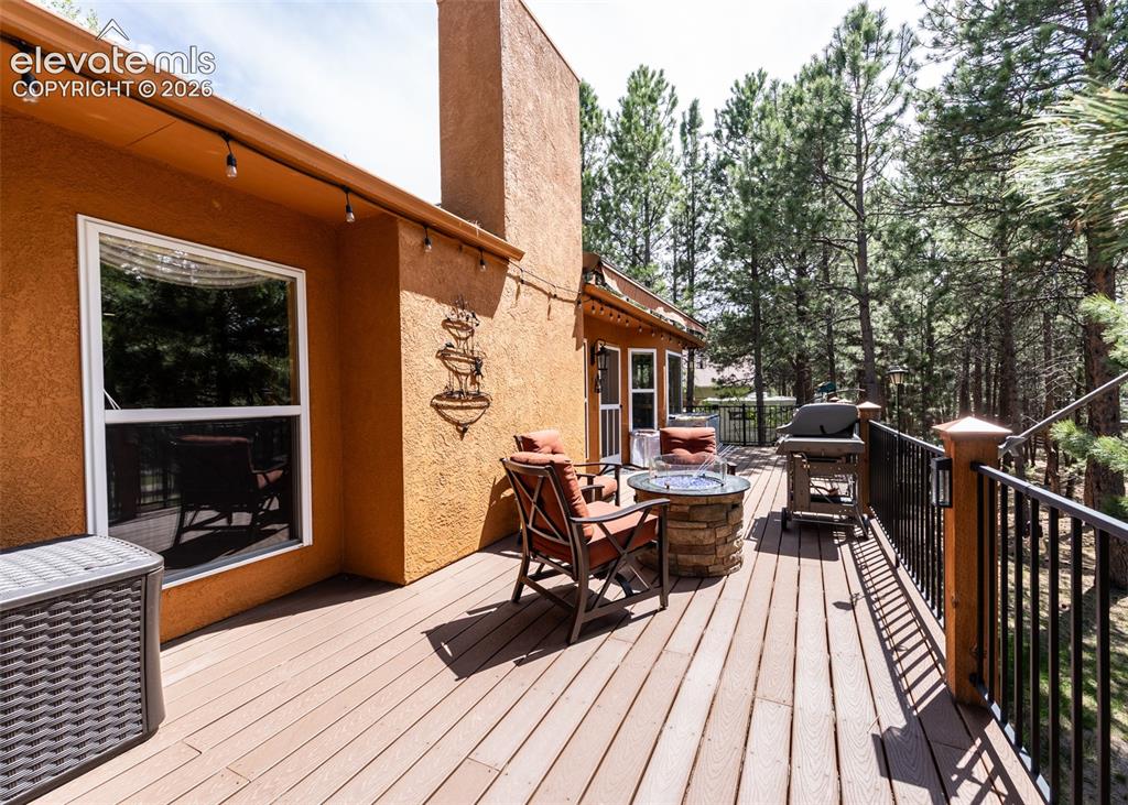 Image 36 of 50: Expansive wood-finish deck with black metal railing