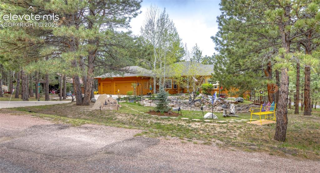 Image 4 of 50: Wood-sided residence with an attached two-car garage