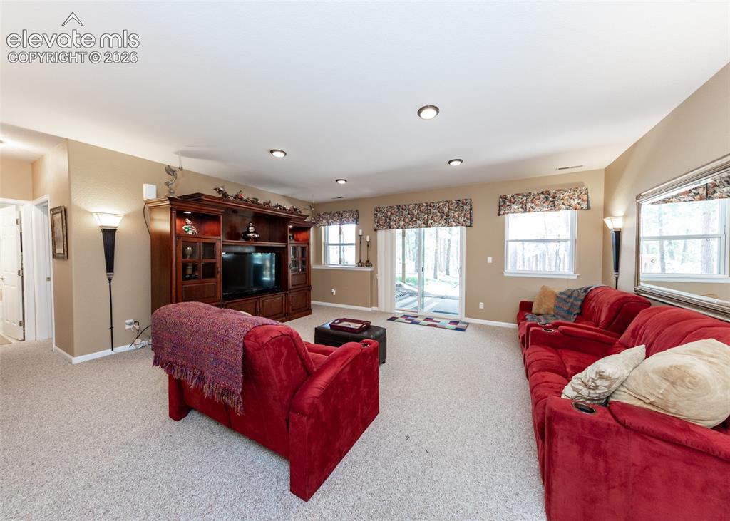 Image 40 of 50: Carpeted living area featuring a built-in entertainment center, recessed li