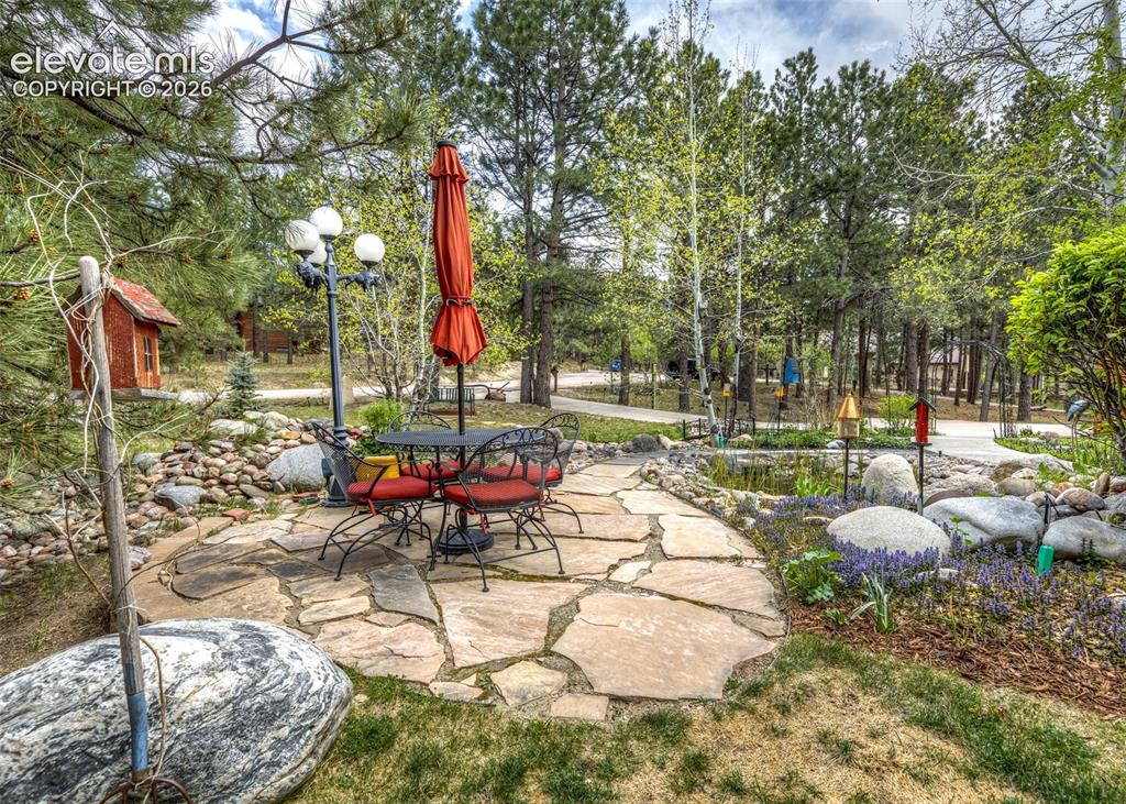 Image 9 of 50: Flagstone patio featuring a lamp post and surrounding landscaping