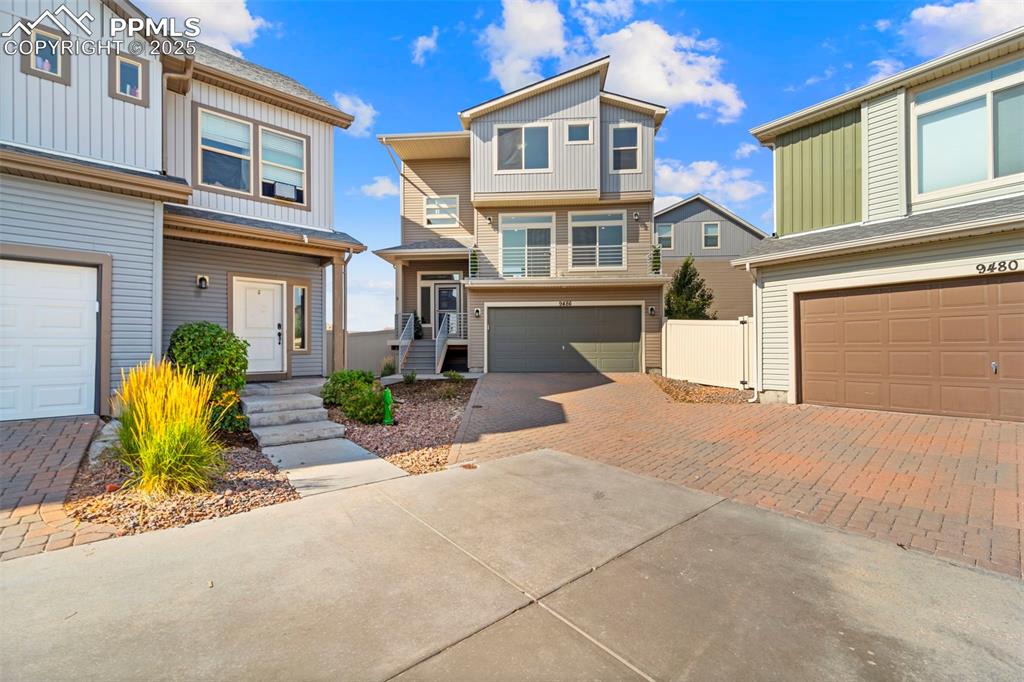 Caption: View of front of property featuring decorative driveway and a garage