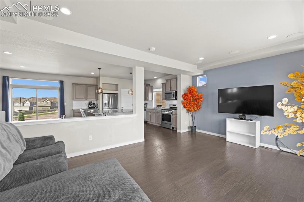 Image 12 of 30: Living room with recessed lighting and dark wood-type flooring