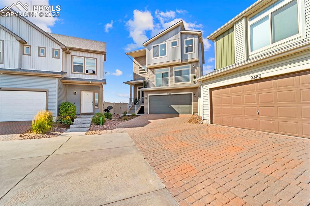 Image 2 of 30: View of front of property with decorative driveway, an attached garage, and