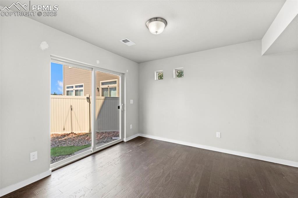 Image 26 of 30: Empty room featuring dark wood finished floors and baseboards