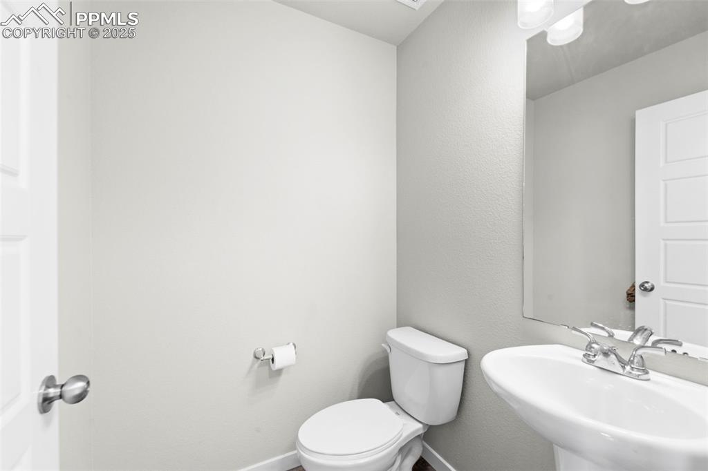 Image 29 of 30: Half bathroom with toilet and a textured wall
