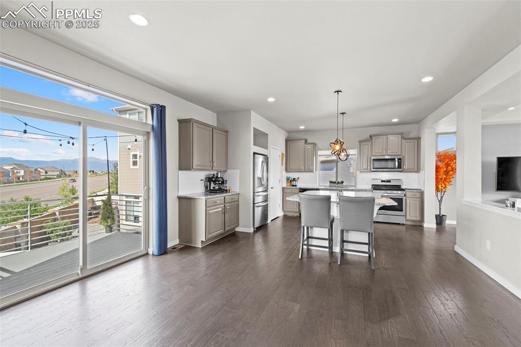 Image 5 of 30: Kitchen with gray cabinetry, a kitchen island, stainless steel appliances, 
