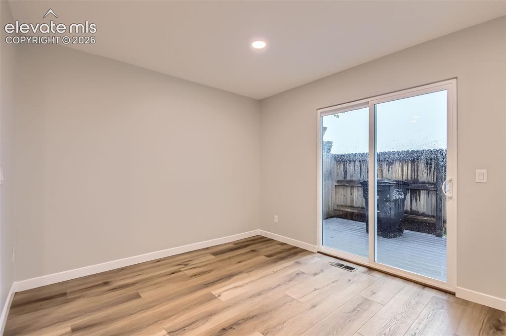 Image 13 of 32: Spacious interior room featuring wood-finish flooring, light neutral wall p