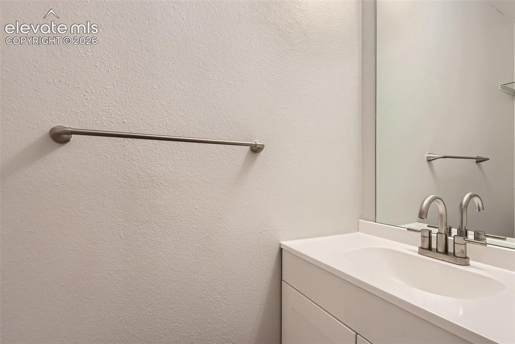 Image 15 of 32: White vanity with an integrated sink and brushed nickel faucet