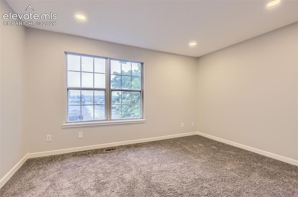 Image 16 of 32: Neutral-toned room featuring a double window with grids, recessed ceiling l