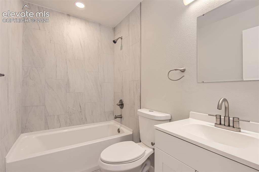 Image 20 of 32: Bathroom featuring a white vanity with an integrated sink, brushed nickel f