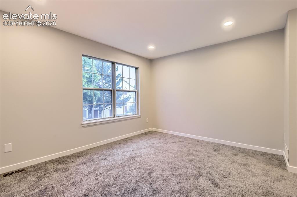 Image 24 of 32: Room featuring gray carpeting, light neutral walls, a multi-pane window, wh