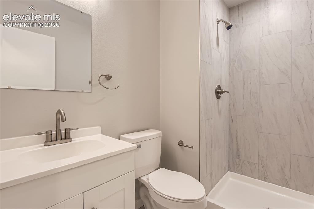 Image 25 of 32: Bathroom featuring a single vanity with an integrated sink, brushed nickel