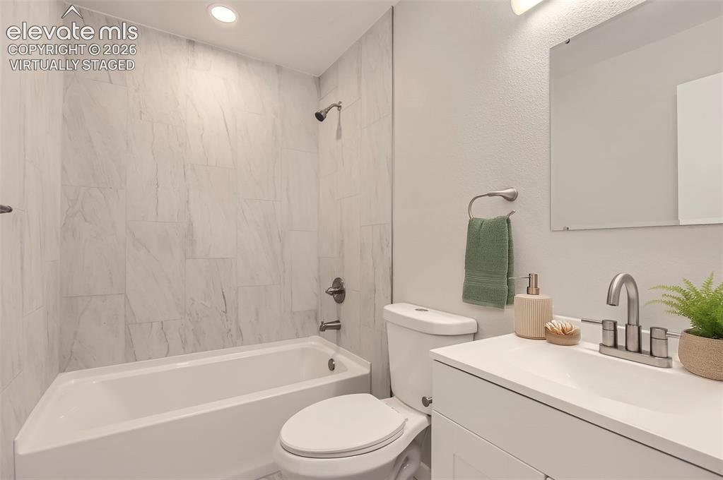 Image 29 of 32: Bathroom featuring a white tub, shower with light-toned tiled surround, whi