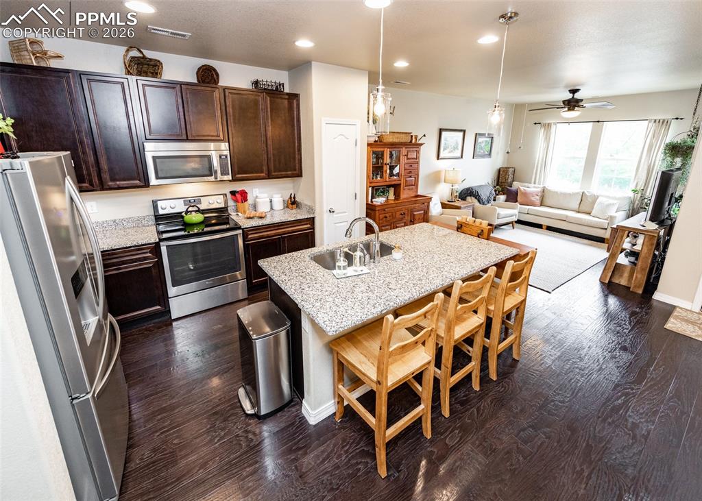 Image 14 of 32: Kitchen with decorative light fixtures, appliances with stainless steel fin