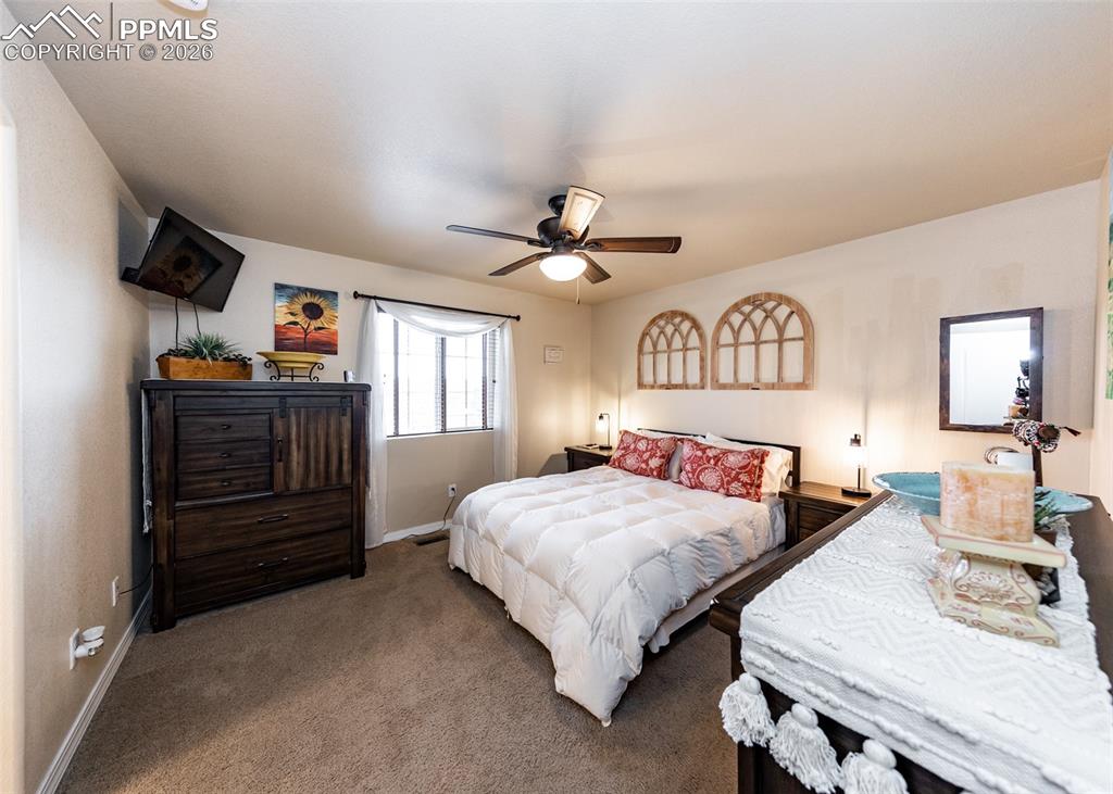 Image 18 of 32: Carpeted bedroom with ceiling fan and baseboards