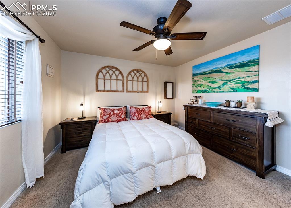 Image 19 of 32: Bedroom with light carpet and ceiling fan