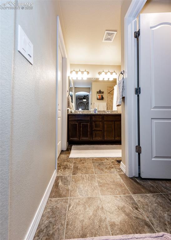 Image 20 of 32: Bathroom with double vanity and a textured wall