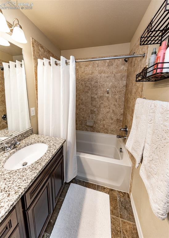 Image 22 of 32: Bathroom with shower / bath combination with curtain and vanity