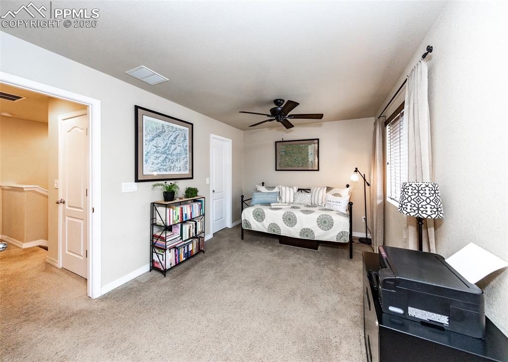 Image 24 of 32: Bedroom with light carpet and a ceiling fan